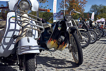 Auffälliges Moped mit Flammendekor neben einem weißen Roller aufgereiht beim Moped-Treffen im JOSKA Glasparadies in Bodenmais.